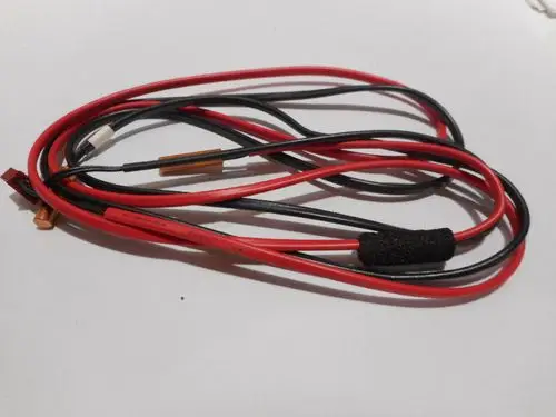 Kabelsystem mit roten und schwarzen Leitungen, teilweise isoliert. An einem Ende sind Anschlussstecker sichtbar, möglicherweise von Remeha für Heizungs- oder Regelungstechnik.
